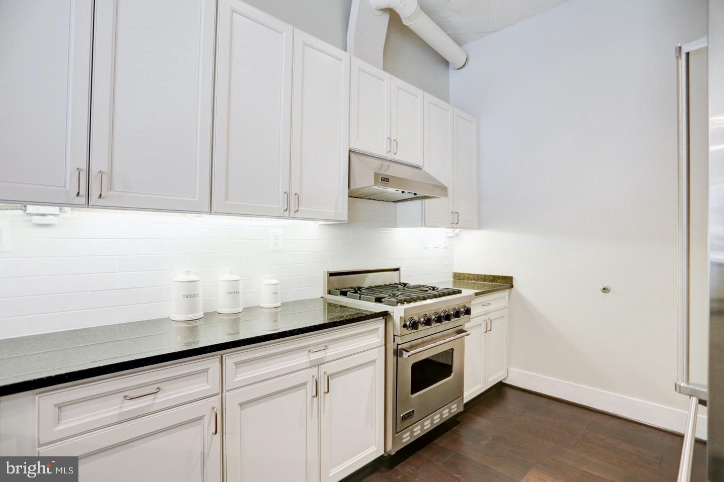 1700 Kalorama Road Northwest, Unit 207 Washington, DC 20009 - Photo 7 of 34 a kitchen with stainless steel appliances granite countertop white cabinets and a stove
