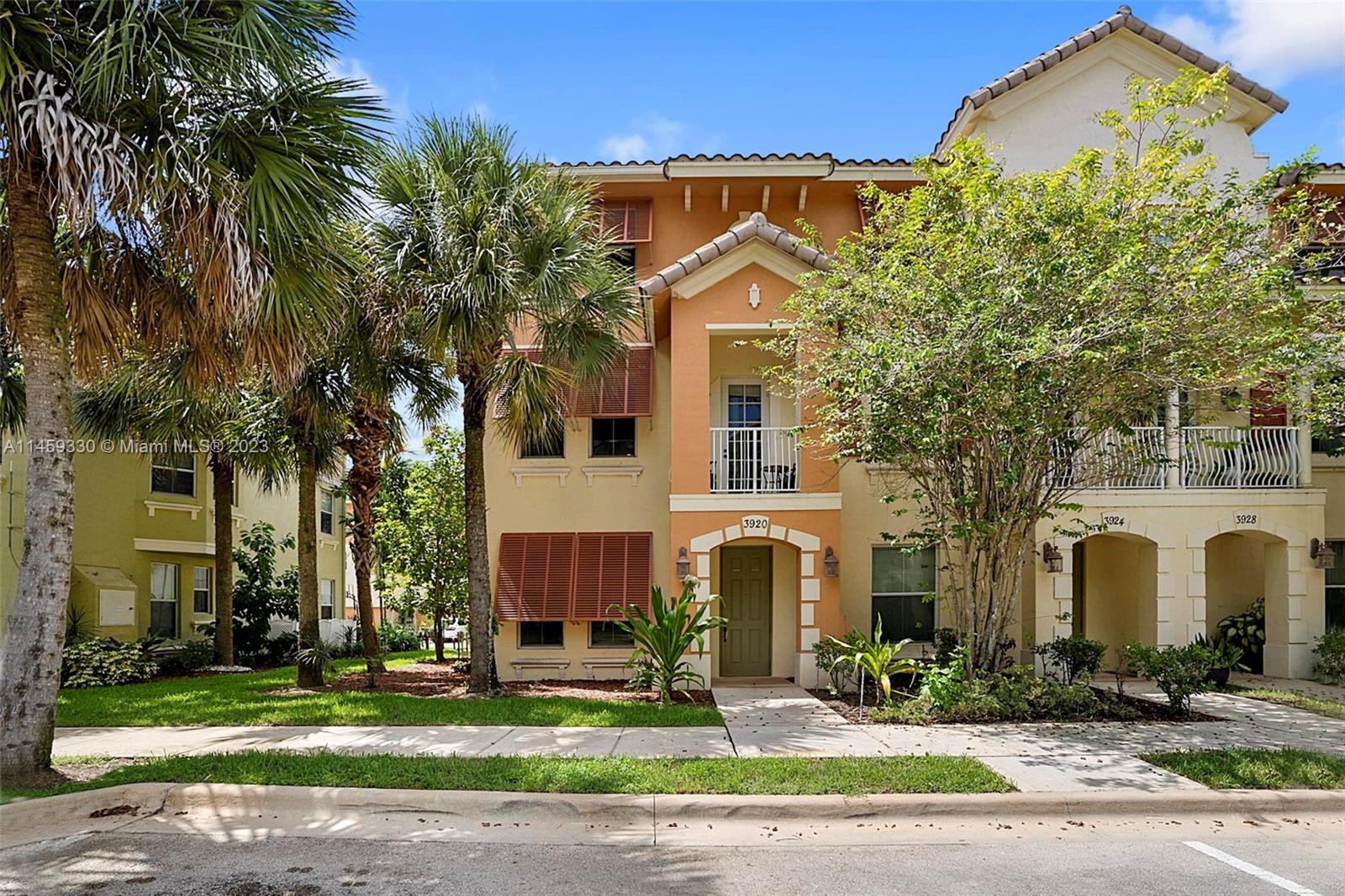 3920 Passion Flower Road Coconut Creek, FL 33073 - Photo 1 of 37 a front view of a building with garden and trees
