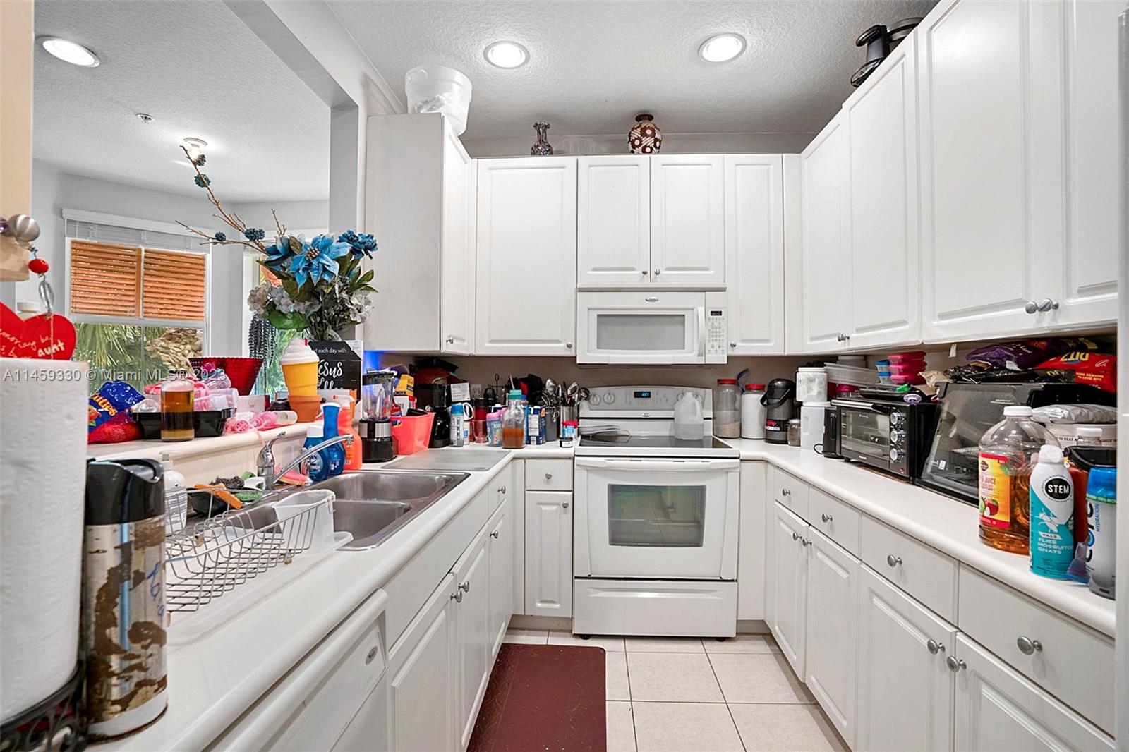 3920 Passion Flower Road Coconut Creek, FL 33073 - Photo 14 of 37 a kitchen with kitchen island granite countertop lots of counter top space and appliances