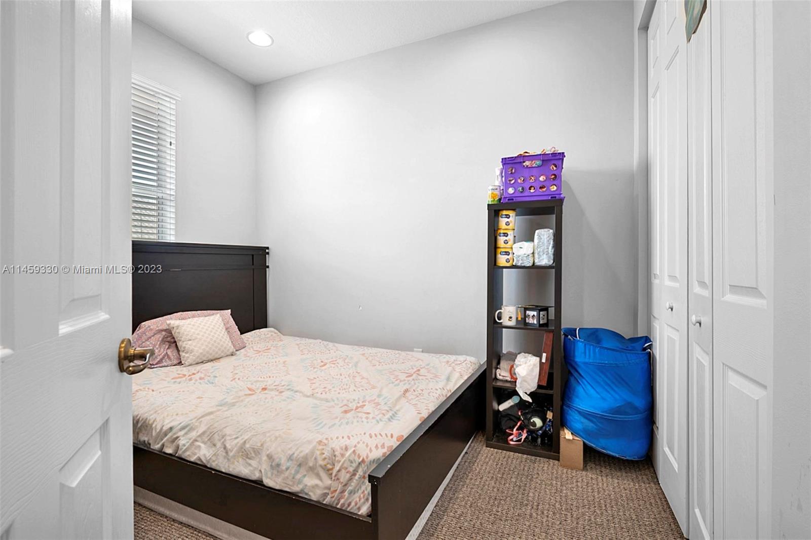 3920 Passion Flower Road Coconut Creek, FL 33073 - Photo 24 of 37 a bedroom with a bed and a bookshelf