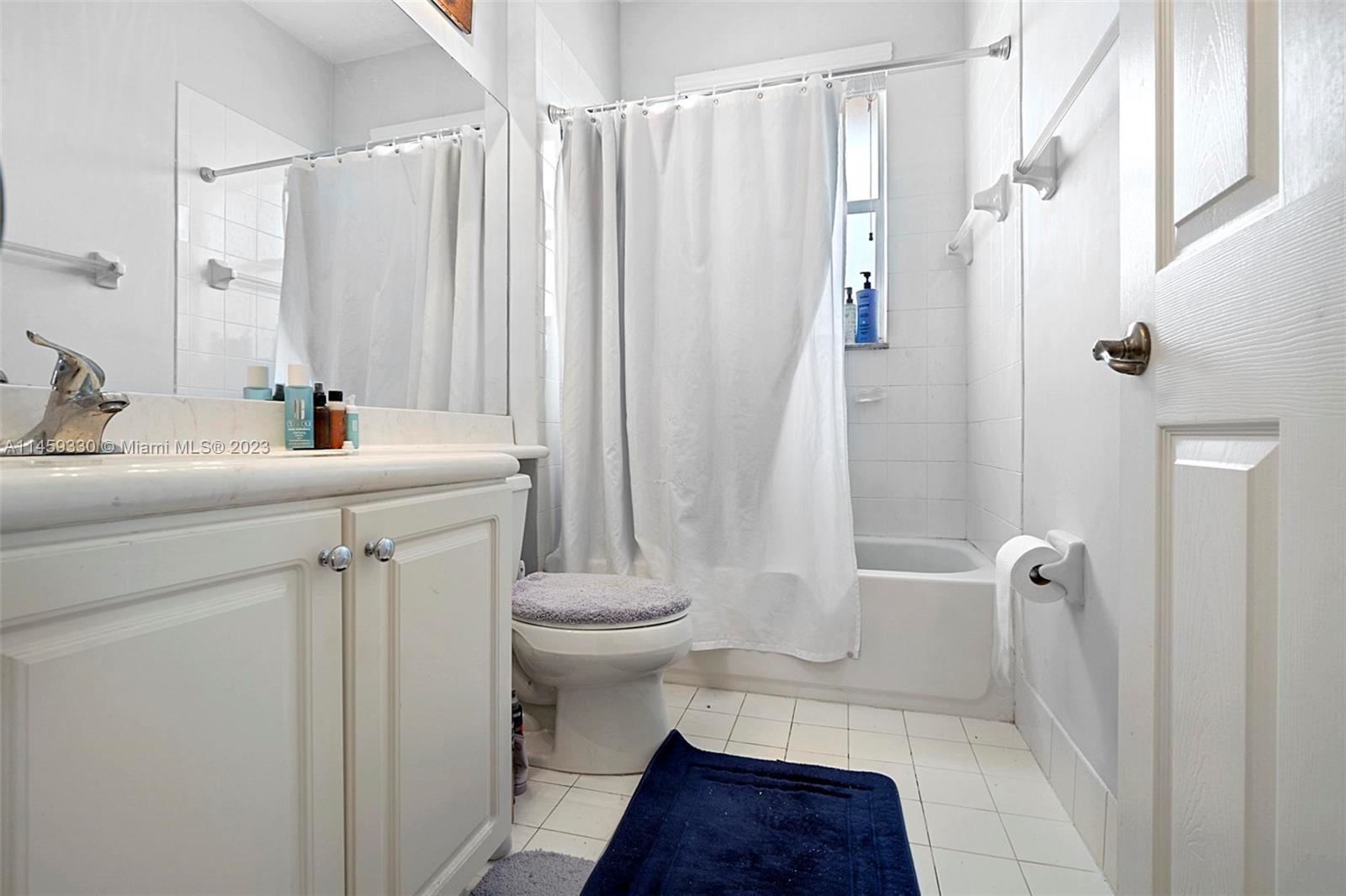 3920 Passion Flower Road Coconut Creek, FL 33073 - Photo 25 of 37 a bathroom with a sink a toilet a mirror and shower