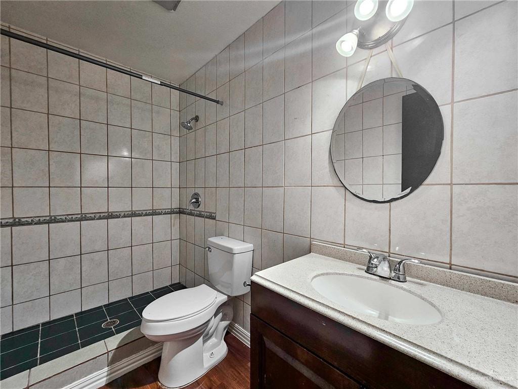 2201 South Jackson Road, Unit 2I Pharr, TX 78577 - Photo 15 of 23 Bathroom featuring a walk-in shower with light-toned wall tiles and dark floor tiles