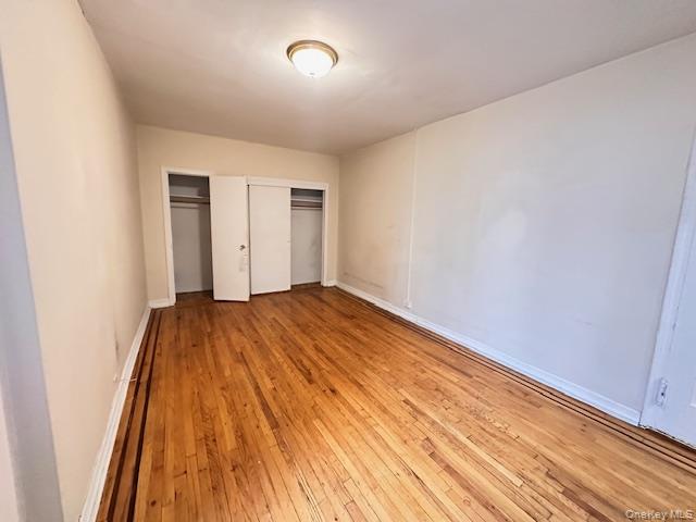 225 Bennett Avenue, Unit 2R Manhattan, NY 10040 - Photo 8 of 25 an empty room with wooden floor and windows