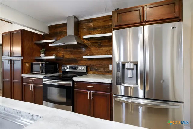 a kitchen with stainless steel appliances granite countertop a refrigerator and a sink