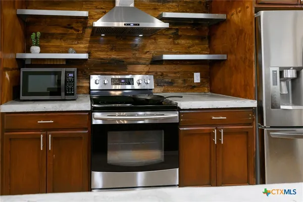 a kitchen with stainless steel appliances granite countertop a stove and a microwave
