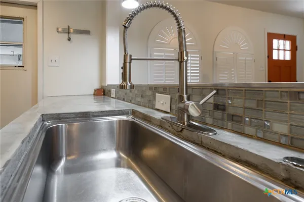 a kitchen with a sink and a mirror