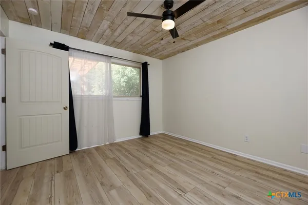 a view of empty room with a window and ceiling fan