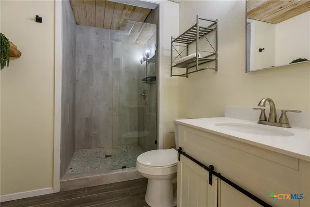 a bathroom with a sink a toilet and shower