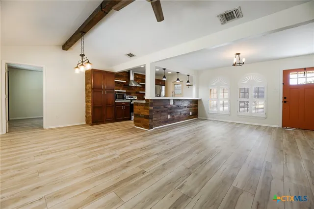 a view of a kitchen with furniture and wooden floor