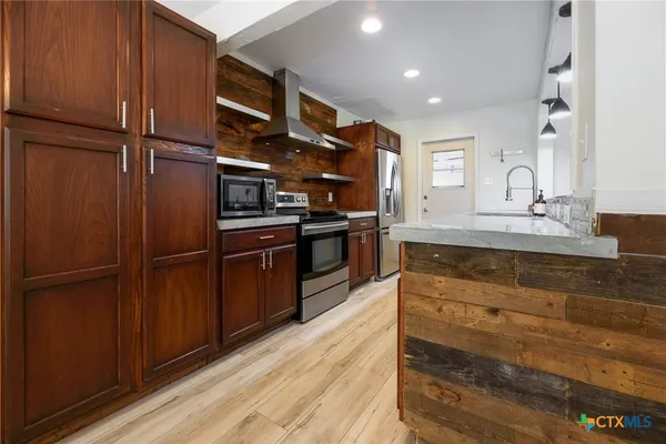 a kitchen with stainless steel appliances granite countertop a refrigerator and a sink