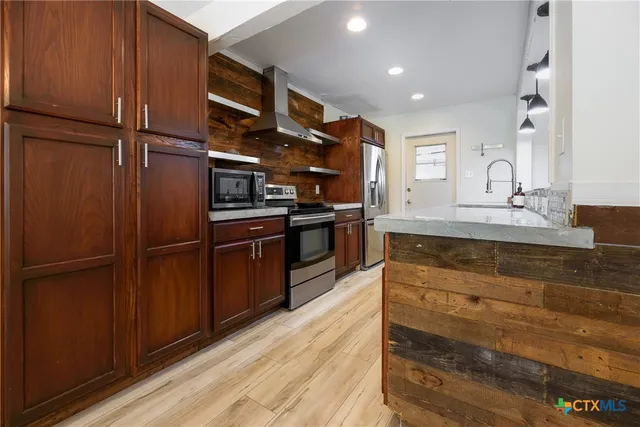 a kitchen with stainless steel appliances granite countertop a refrigerator and a sink