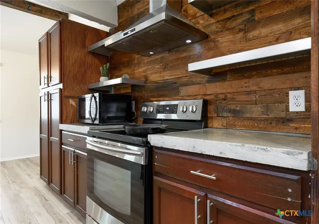a kitchen with stainless steel appliances granite countertop a stove and a microwave