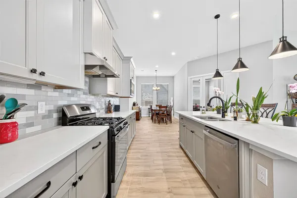 a large kitchen with stainless steel appliances lots of counter space and a sink