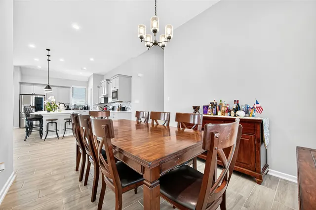 a dining area with furniture a chandelier and wooden floor