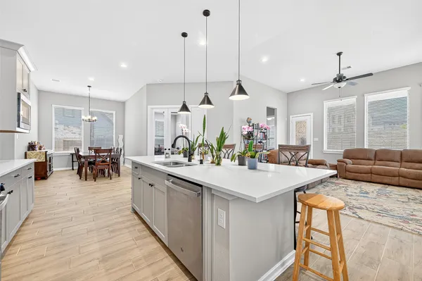 a kitchen with stainless steel appliances granite countertop a sink a stove and a wooden floors
