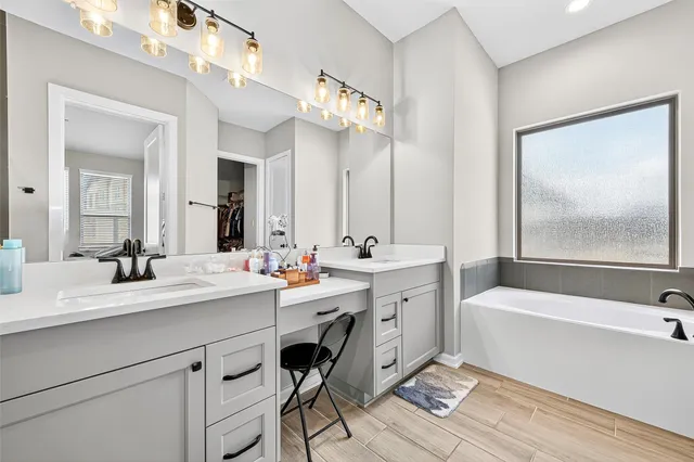 a bathroom with a sink a large mirror and a bathtub
