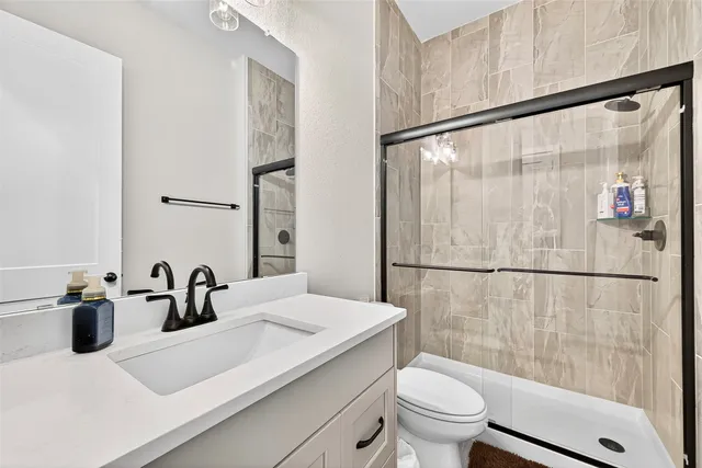 a bathroom with a sink mirror toilet and shower