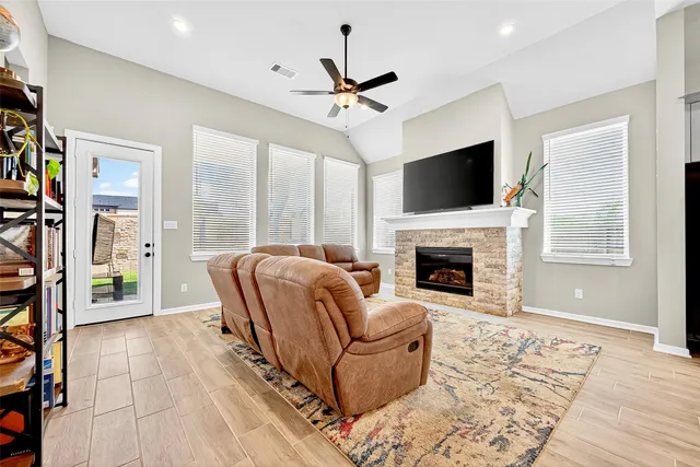 a living room with furniture a flat screen tv and a fireplace