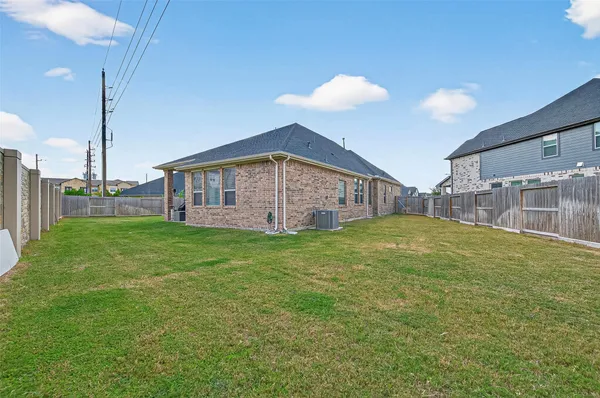 a view of a house with a backyard and a tree