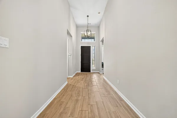 a view of a hallway with wooden floor and a staircase