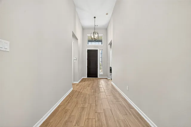 a view of a hallway with wooden floor and a staircase