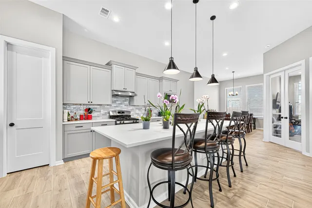 a kitchen with stainless steel appliances kitchen island granite countertop a table and chairs in it