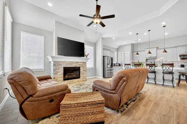 a living room with furniture a flat screen tv and a fireplace