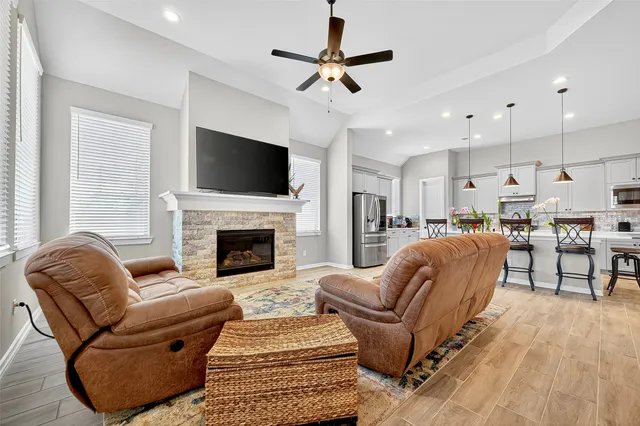 a living room with furniture a flat screen tv and a fireplace
