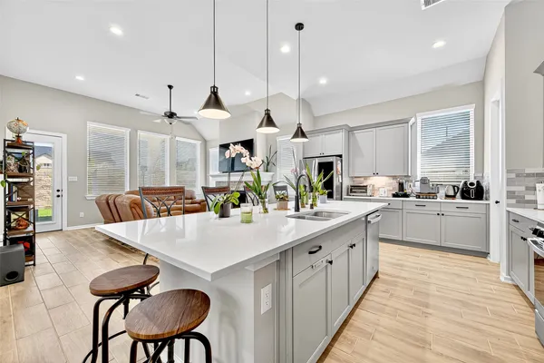 a large kitchen with cabinets a counter space a sink appliances and a large window