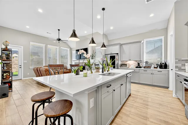 a large kitchen with cabinets a counter space a sink appliances and a large window