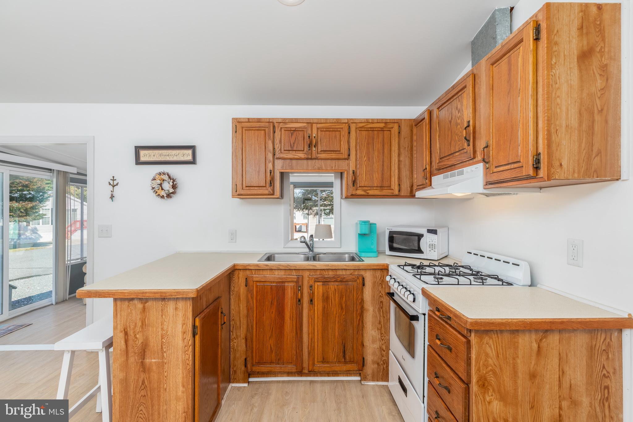 380 Seahawk Lane Berlin, MD 21811 - Photo 25 of 72 a kitchen with a sink a stove cabinets and a window