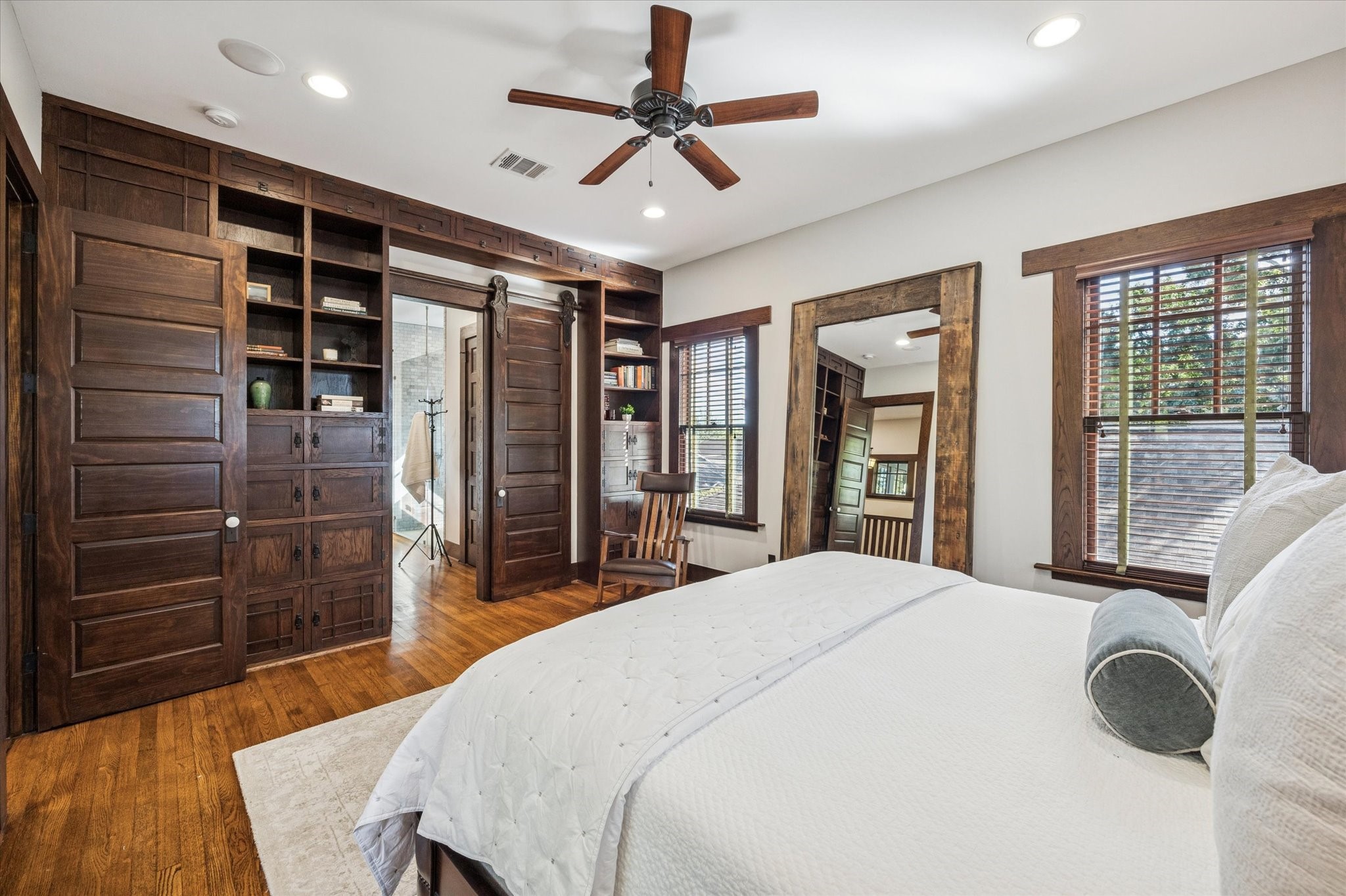 512 Archer Street Houston, TX 77009 - Photo 22 of 40 The bedroom includes a full wall of built-in shelves and storage, complemented by a solid wood sliding door on casters to the ensuite bath.