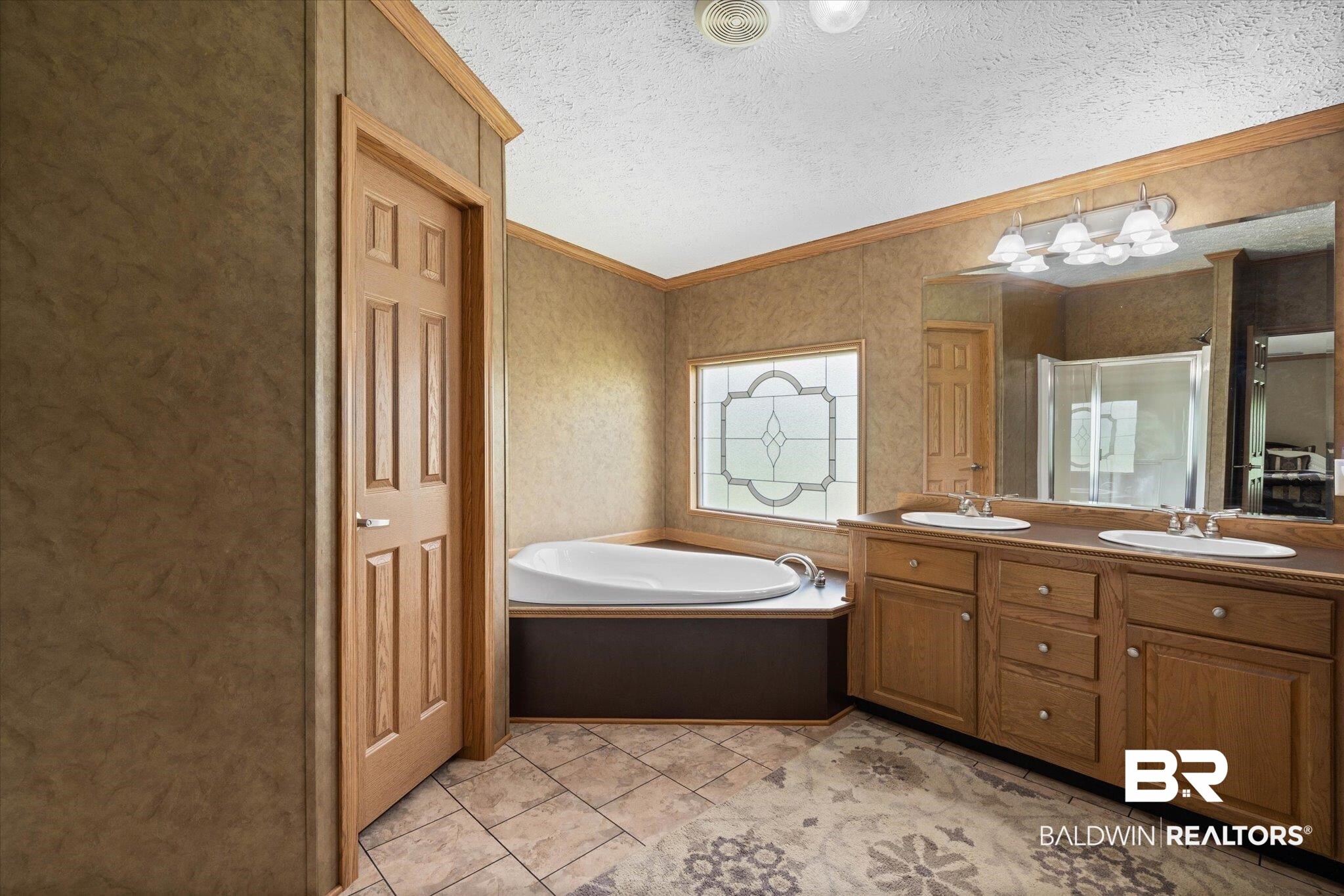 9335 Nathan Jordan Road Millry, AL 36558 - Photo 13 of 20 Full bathroom with double vanity, a stall shower, a bath, crown molding, and vaulted ceiling