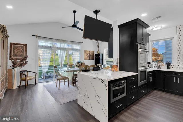 a open kitchen with stainless steel appliances a stove top oven and refrigerator