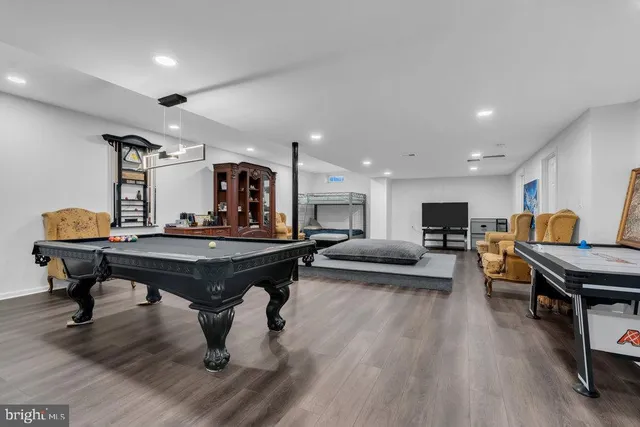 a living room with furniture a piano and a bookshelf