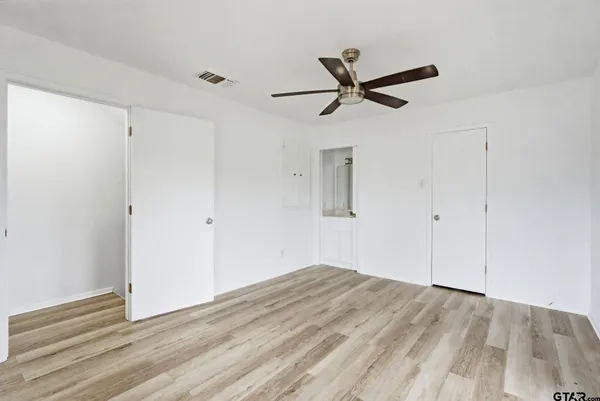 a view of empty room with wooden floor