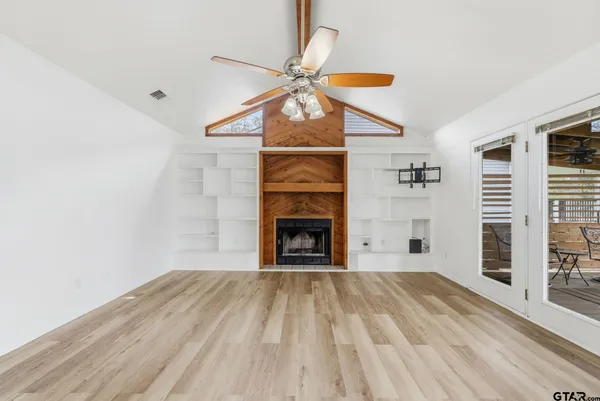 a view of empty room with fireplace and fan