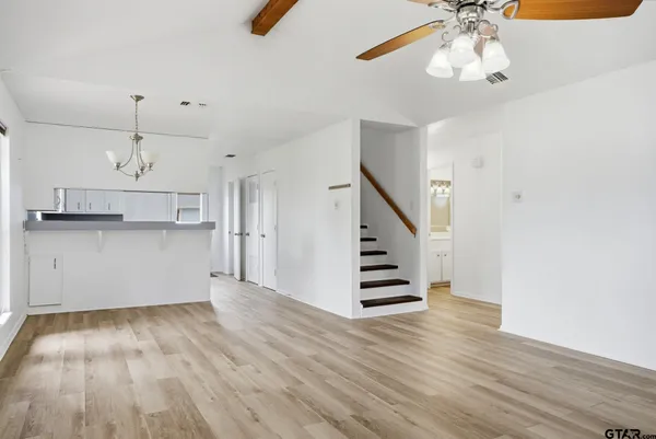 a view of a kitchen with wooden floor and cabinets
