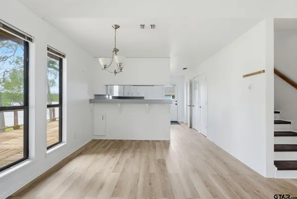 a view of a kitchen with wooden floor and windows