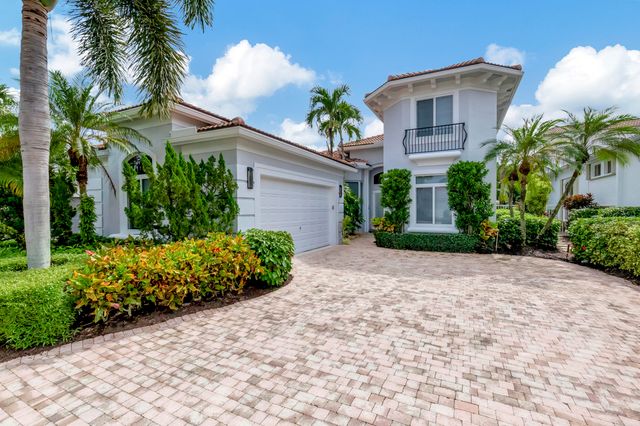 a front view of a house with a yard and potted plants