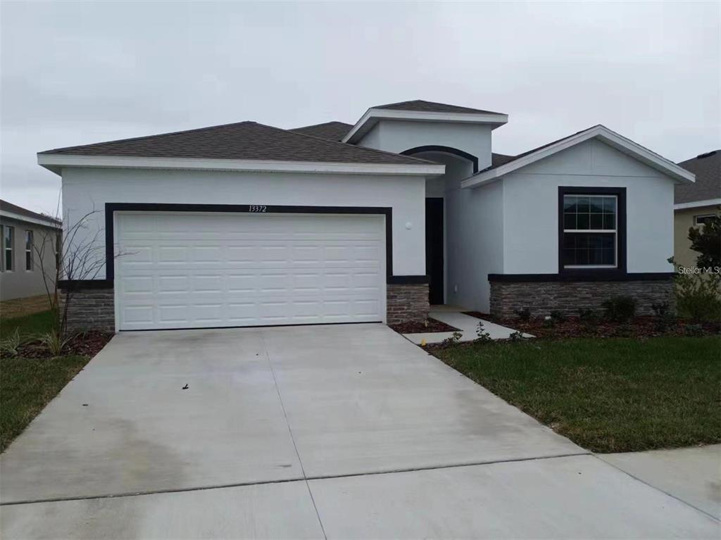13372 Golden Lime Ave Spring Hill Spring Hill, FL 34609 - Photo 1 of 18 a front view of a house with a yard and garage