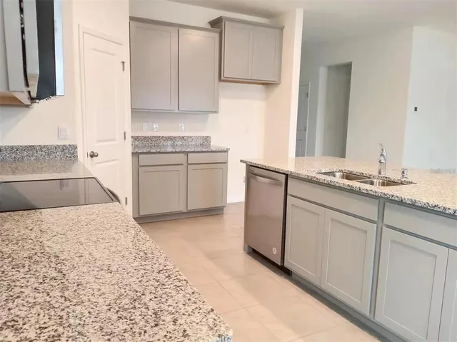 a kitchen with granite countertop a sink and a stove