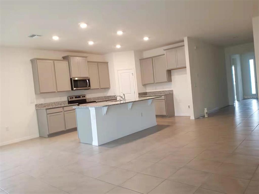 13372 Golden Lime Ave Spring Hill Spring Hill, FL 34609 - Photo 5 of 18 a kitchen with stainless steel appliances a refrigerator sink and cabinets