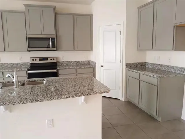 a kitchen with stainless steel appliances granite countertop a sink and a microwave