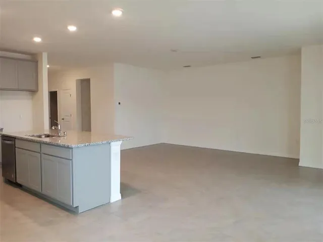 a kitchen with granite countertop white cabinets and sink