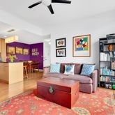 a living room with furniture cabinets and kitchen view