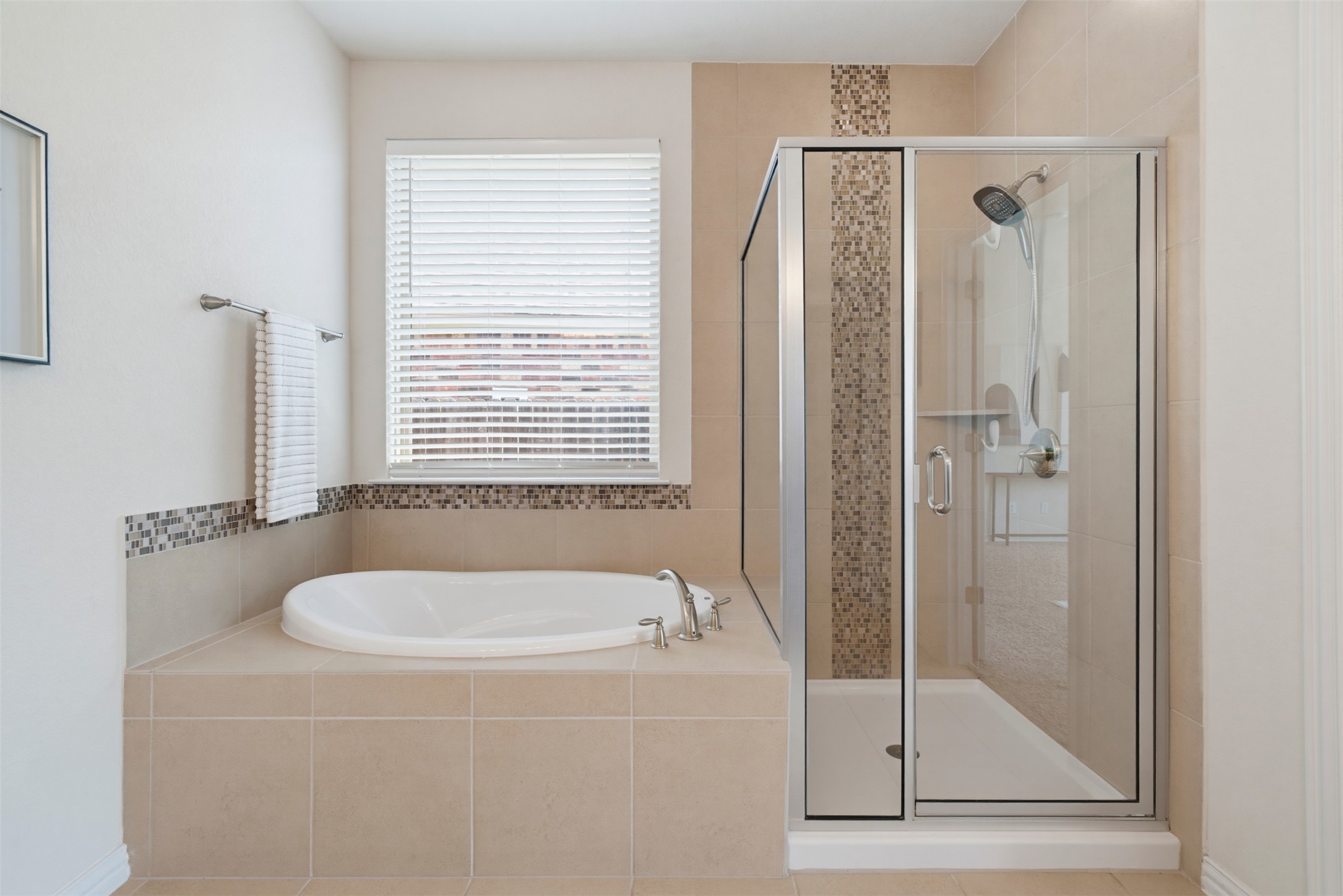 12613 Twisted Root Drive Manchaca, TX 78652 - Photo 13 of 33 Unwind in the primary bath, featuring a soaking tub and a sleek glass-enclosed shower.