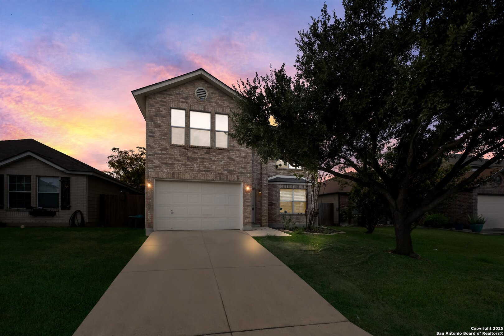 a front view of a house with a yard and trees
