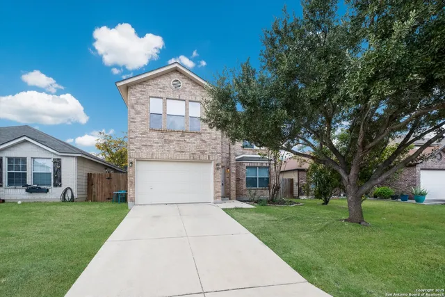 a front view of a house with a yard and an trees