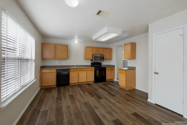 a kitchen with a refrigerator and a stove top oven